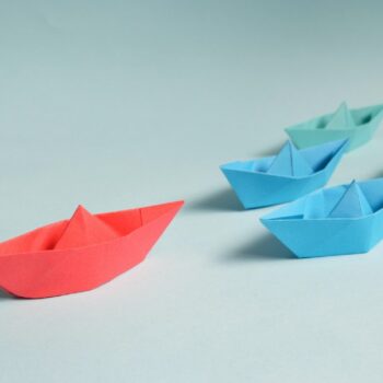 Four origami paper boats in a line